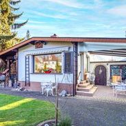 Hausansicht vom Garten mit überdachter Terrasse