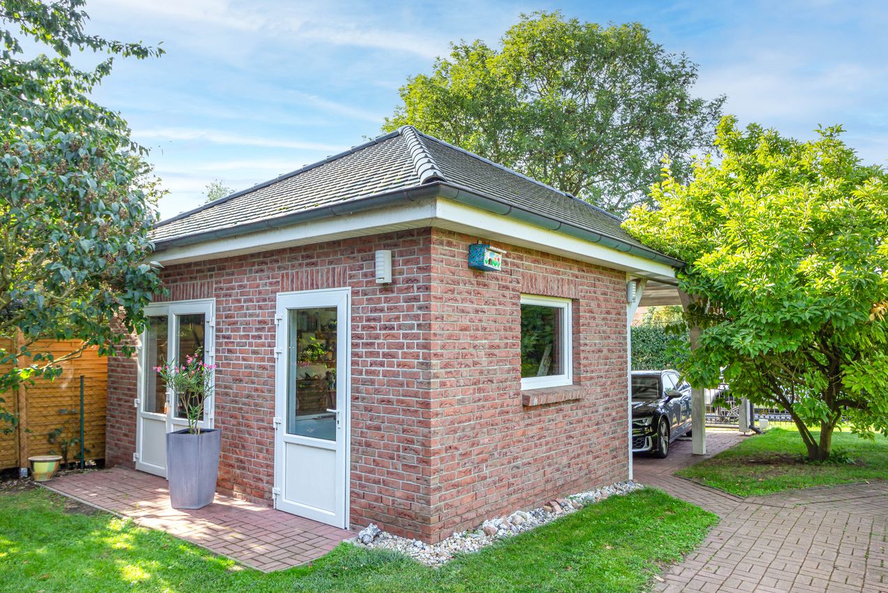 Massives Nebengebäude mit Fitnessraum und Doppelcarport an der Straßenfront