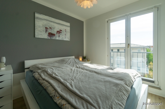 Schlafzimmer mit bodentiefem Fenster