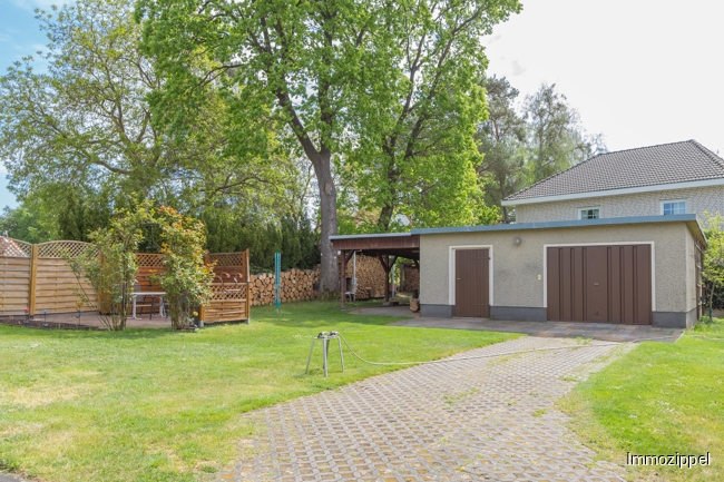 Gartenansicht mit Garage und Carport