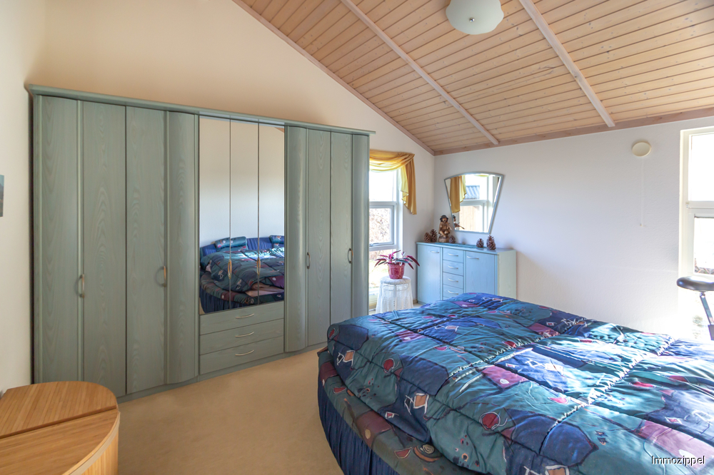 Großes Schlafzimmer mit bodentiefen Fenstern
